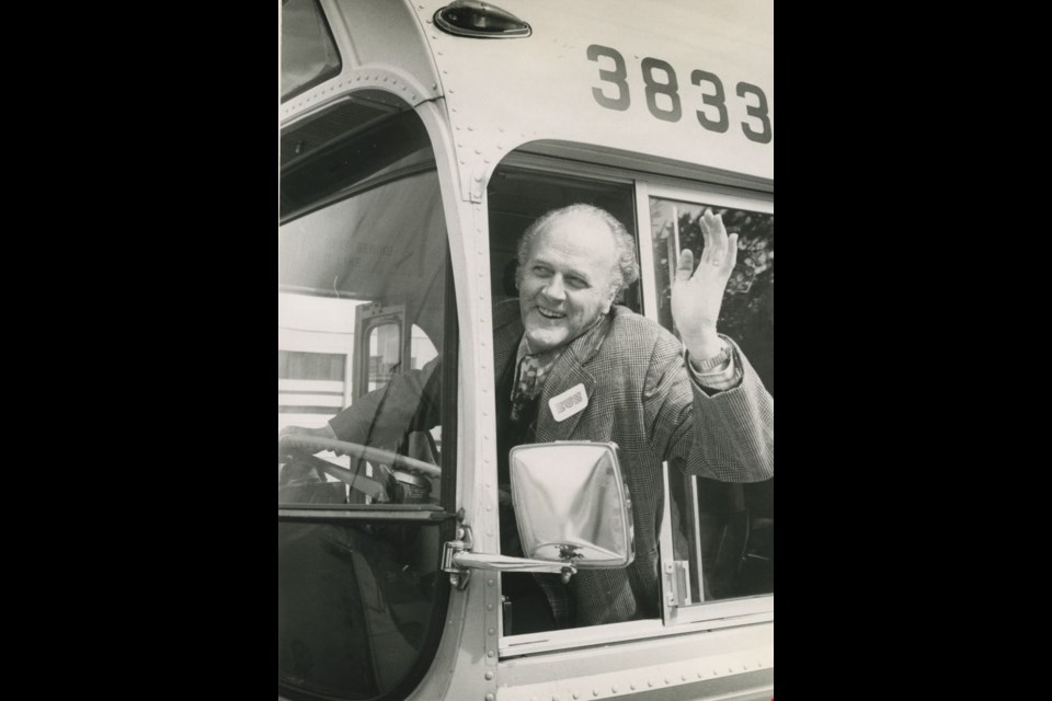 Municipal Affairs Minister Jim Lorimer waves to crowd gathered for ribbon-cutting ceremony opening 49th Avenue bus service in Burnaby. After snipping the ribbon, Lorimer tried out the bus driver's seat but didn't actually drive the bus, according to newspaper records.