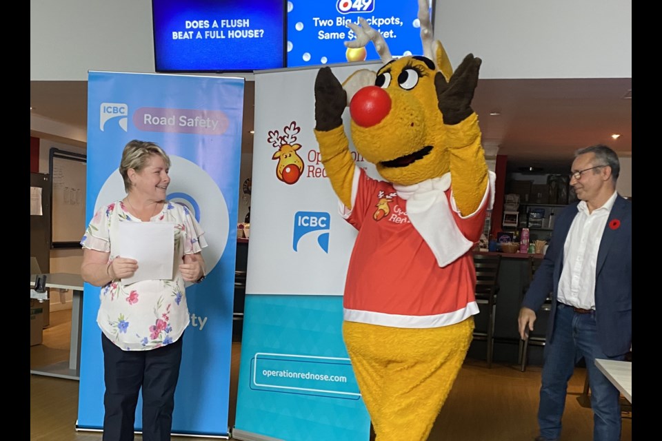 Jackie Weinkam (left) and Chris Wilson (right) welcome Rudy (centre), Operation Red Nose's "first volunteer" and beloved mascot.