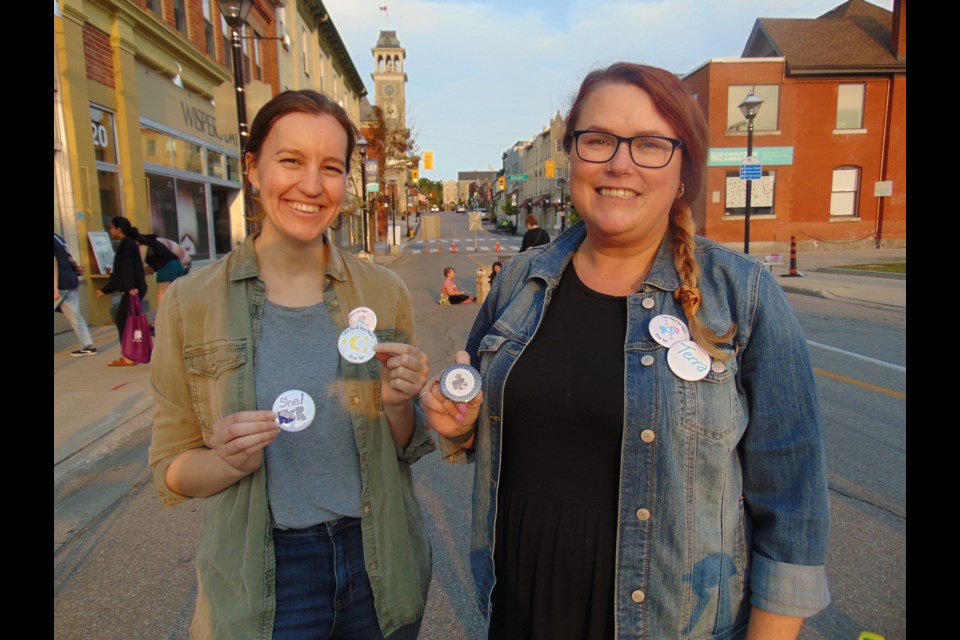 Shannon Thoms and Terra MacDonald from the YWCA make buttons for supporters at Take Back the Night in Cambridge during last year's event.                                