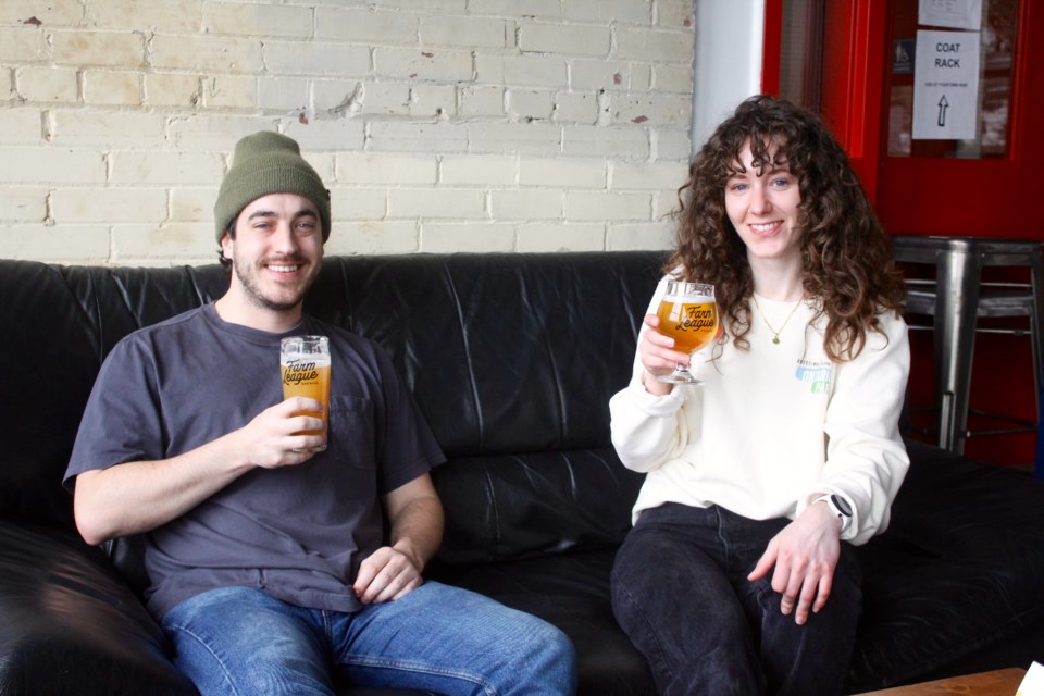 Co-owner of Farm League Brewing Collin McKinnon (left) and head of events and marketing Jocelyn Kivell sit in the lounge area of Farm League Brewing's entertainment space.