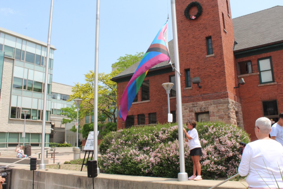 The Pride flag makes its way up the pole.