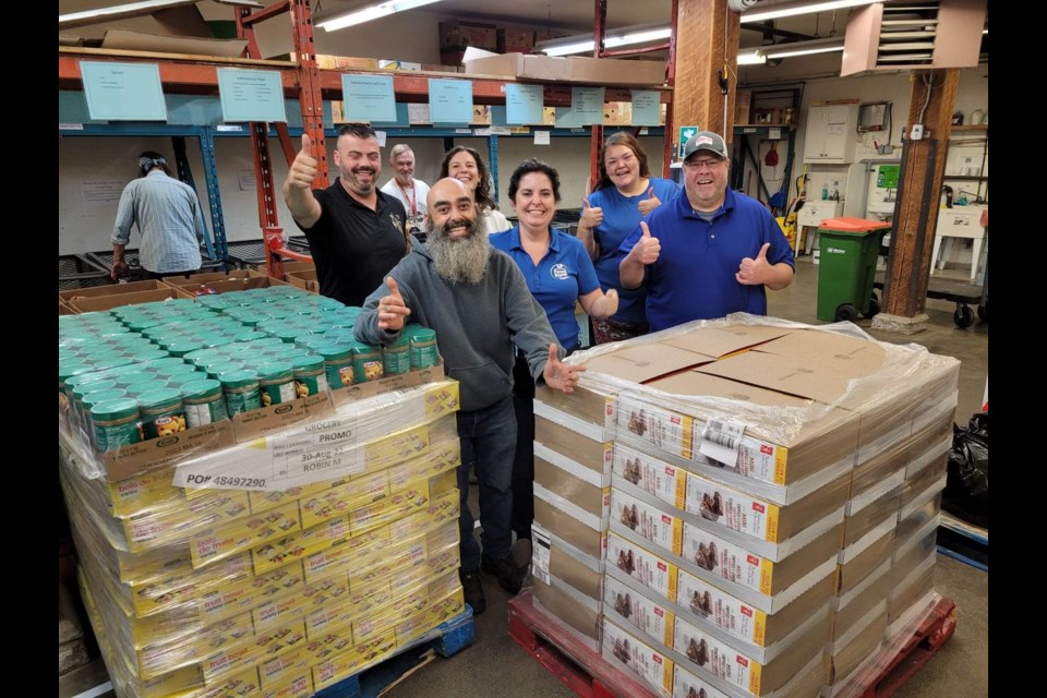 Members of the Cambridge Food Drive Initiative show off the donations they collected alongside Cambridge Food Bank Executive Director Dianne McLeod.