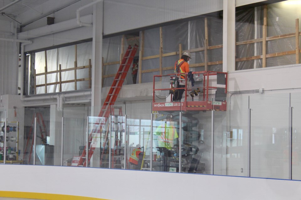 Construction crews work on the windows overlooking the soon to be completed second rink at the Cambridge Sports Park.