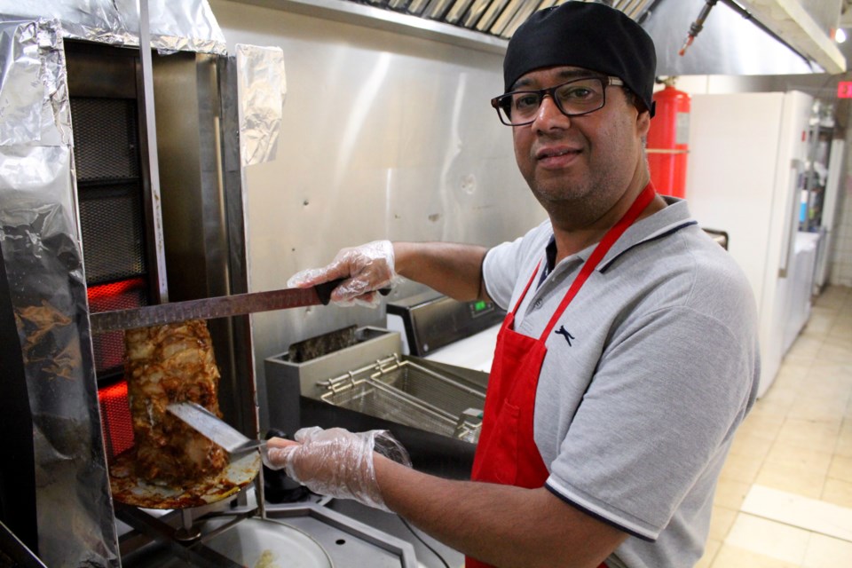 Fareid Ahmadi cooks up some meat in the kitchen of his newly opened Tops Shawarma restaurant in Galt.