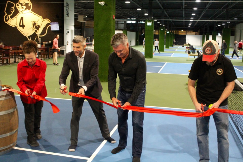 Pickleball manager Patricia Jamieson (left), Four Fathers co-owner Marty Castellan, Ward 6 councillor Adam Cooper, and co-owner Mike Hruden cut the ribbon to officially open the brewery's pickleball facility.