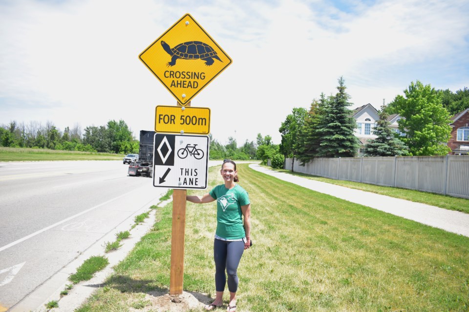 Kara Klypycz stands beside the newly installed turtle crossing sign on Can-Amera Parkway in Cambridge in which she spent nearly a year advocating to have installed. 