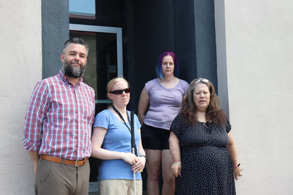 Residents Ryan Anningson, Beverly Dejong, Chel Willard and Lisa Geddes stand in front of their building at 35 Water St. S