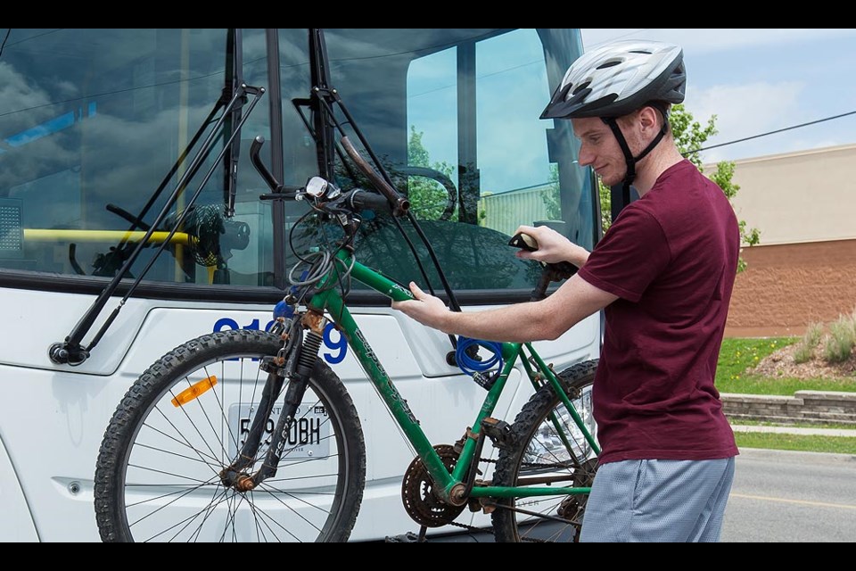 A GRT rider loads his bike onto a bus 