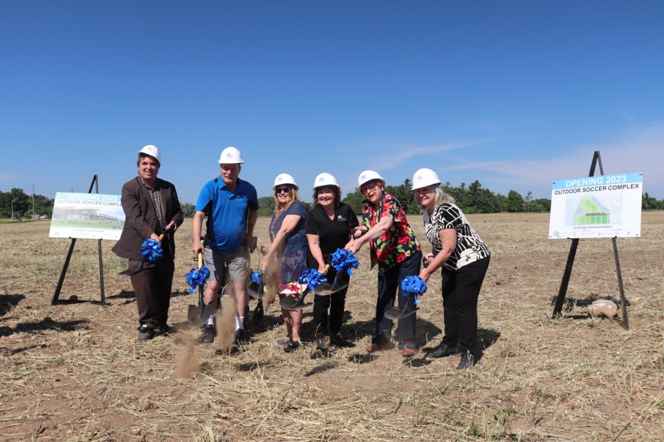 Cambridge city councillors throw the ceremonial first dig into the air at the Linden Drive soccer complex.