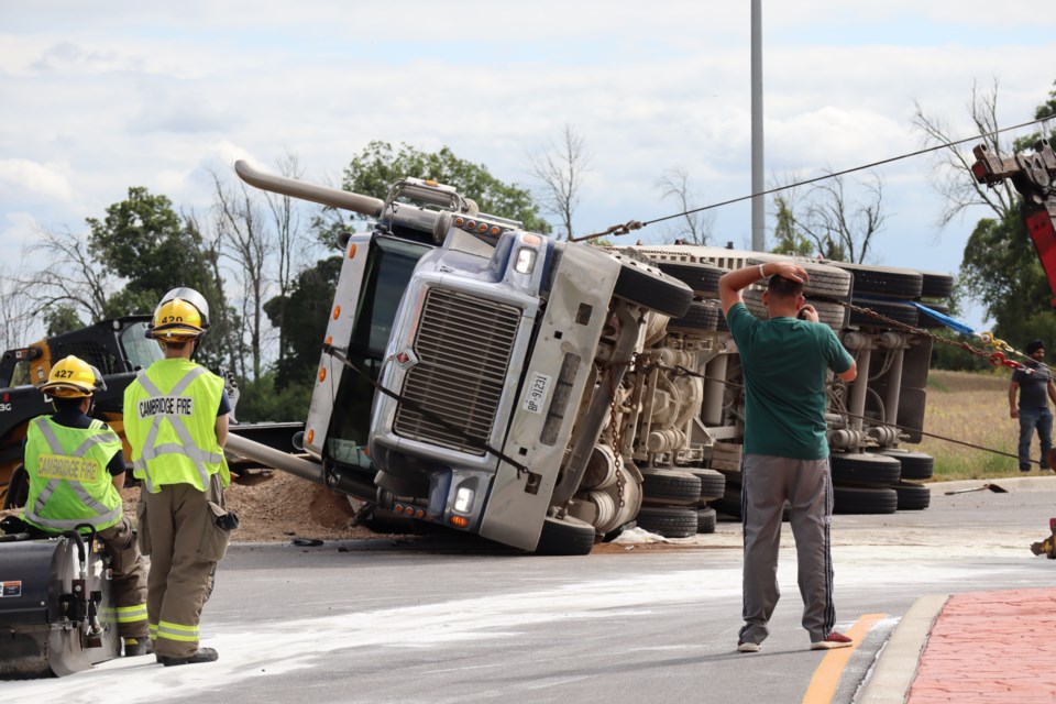 Tow crews pull the gravel truck back to its wheels after turning on its side after it rolled on a curb on McQueen Shaver Boulevard on Wednesday afternoon. 
