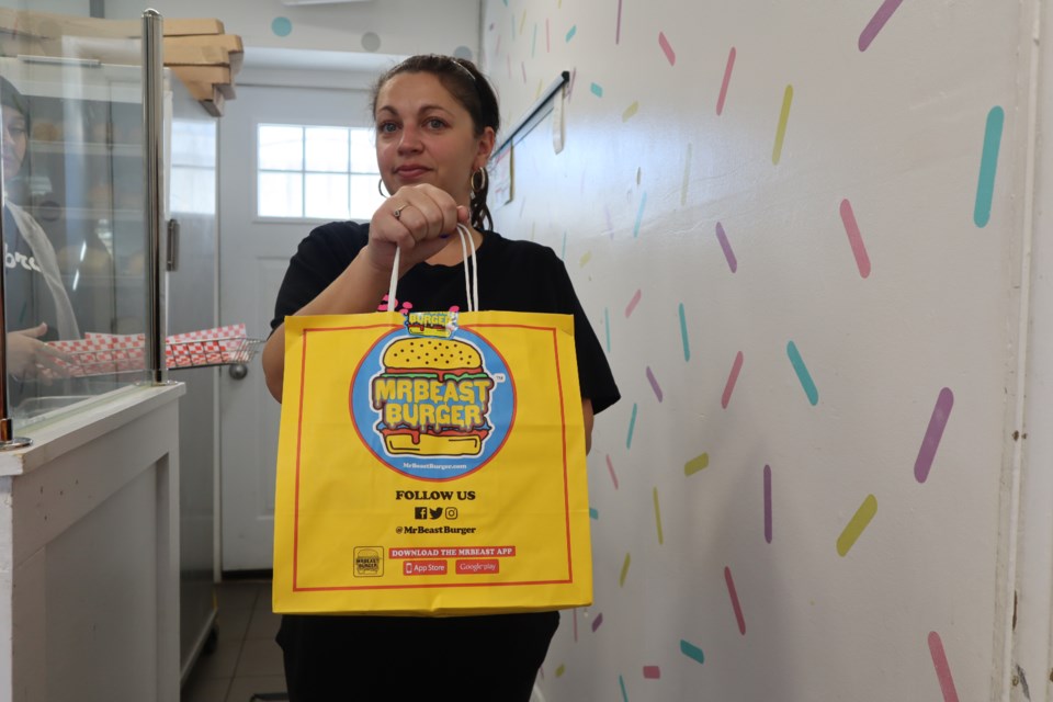 Nancy Faria, manager of Siebra, holds a Mr. Beast Burger bag ready for the customer to take and enjoy