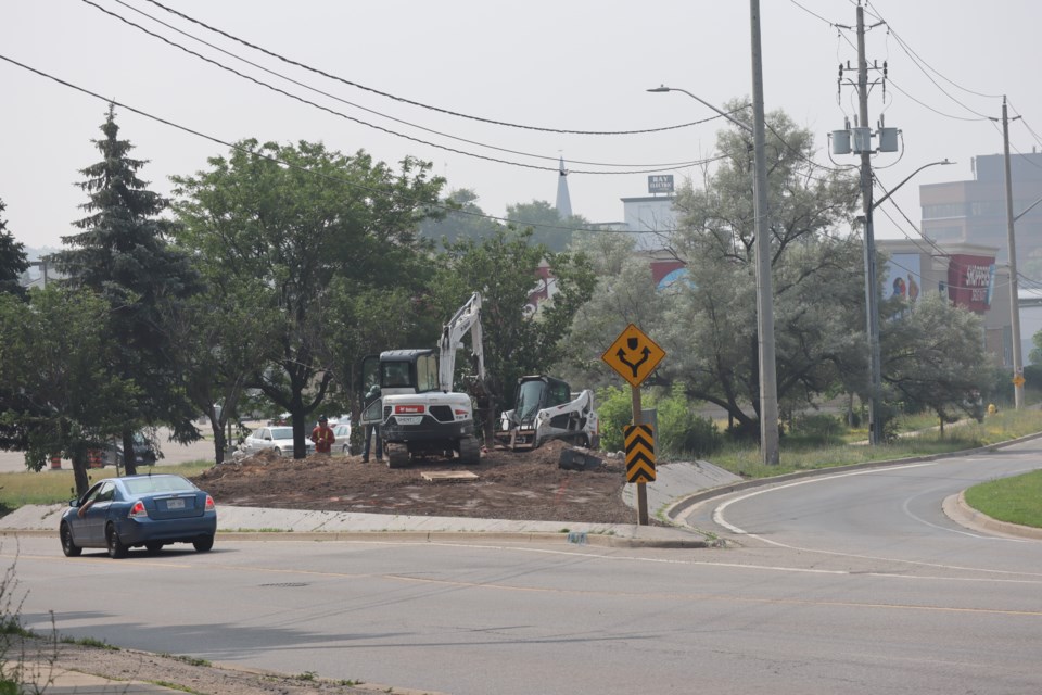 Construction crews demolish the Galt City Centre sign only a few days after planting large amounts of flowers at the intersection.