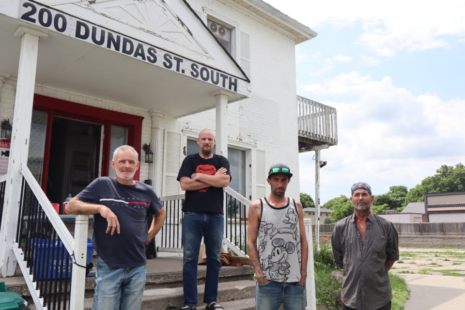 Residents of 200 Dundas St. S. stand in front of their building that is supposed to be vacant