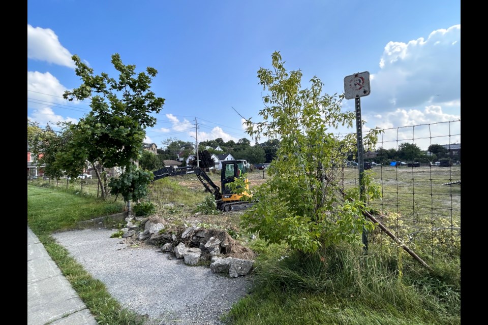 Workers start removing brush to make way for a new development at 55 Kerr St. 