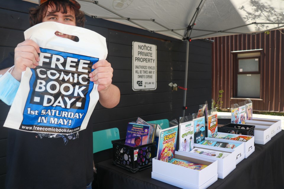 A volunteer holds up a bag for comics at Retro Rocket Comics on Free Comic Book Day