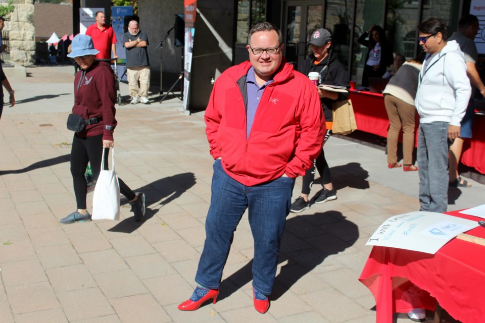 MP Bryan May sporting red high heels to raise awareness for gender-based violence.