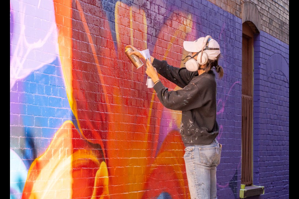 Artist Meaghan Claire Kehoe works her magic on the side of a building in downtown Cambridge.