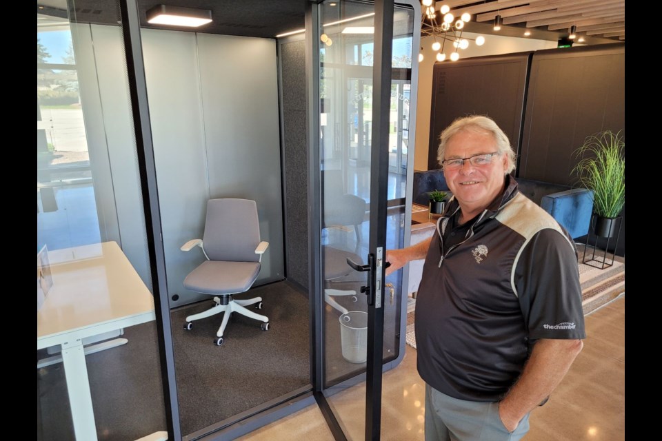 Cambridge Chamber president Greg Durocher shows off one of the pod workspaces that are a main feature of The Link.