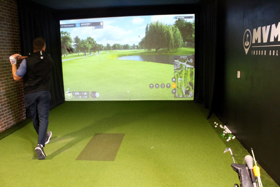 Sean Mathers watches his shot on one of the simulator screens at MVM Indoor Golf