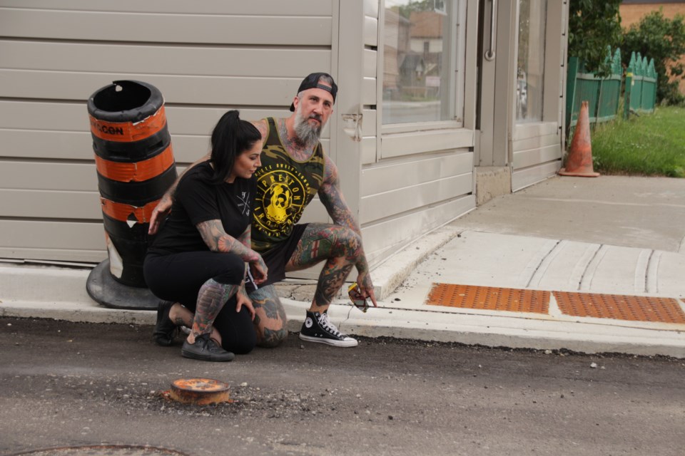 Laura Richelle Bernadette and Josh Dawson on Dolph Street across from their tattoo studio and home where a man in his wheelchair toppled over the curb Monday night.
