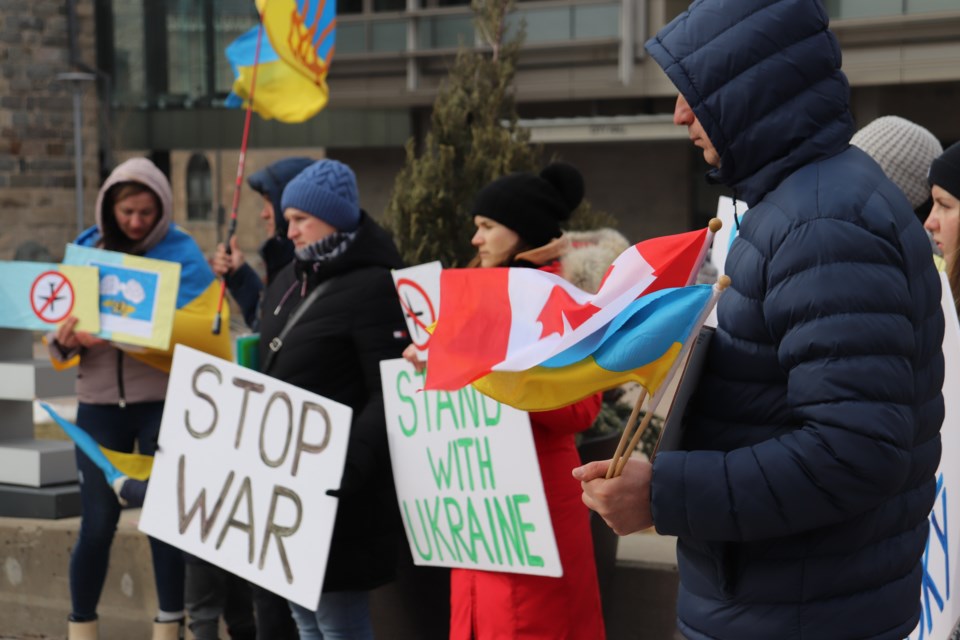 Ukraine and Canada flag flying side by side at a rally at Cambridge City Hall on Saturday.