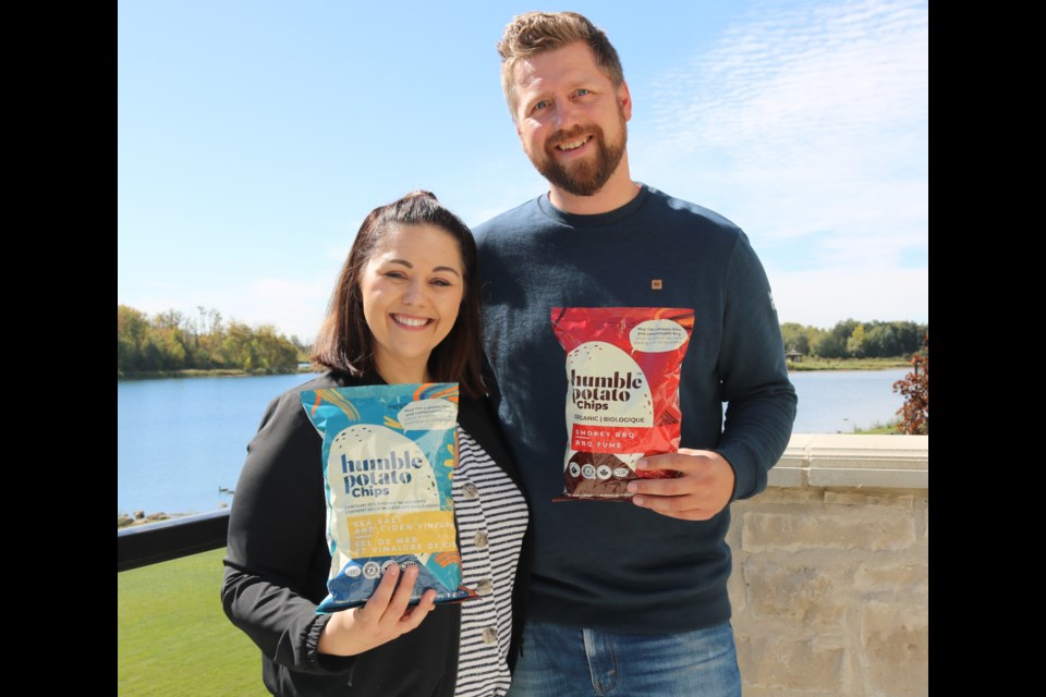 Alicia Lahey and Jeff Lahey each posing with a bag of Humble Potato Chips.