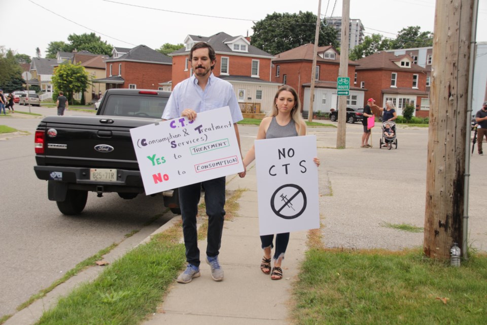James Dover and Kathryn Schuiling walk toward 15 Easton St., one of the two proposed sites for a consumption and treatment services set up.