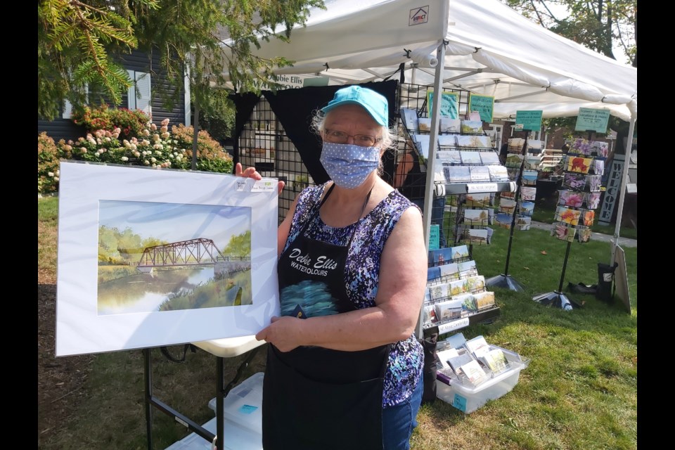 Debbie Ellis, a local artist who creates watercolour renditions of famous Cambridge landmarks, holds up a Blackbridge painting.
