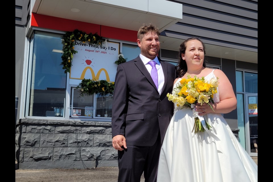 Phil and Stephanie Hammond pose next to the drive-thru window at McDonalds following their Tuesday afternoon nuptials.