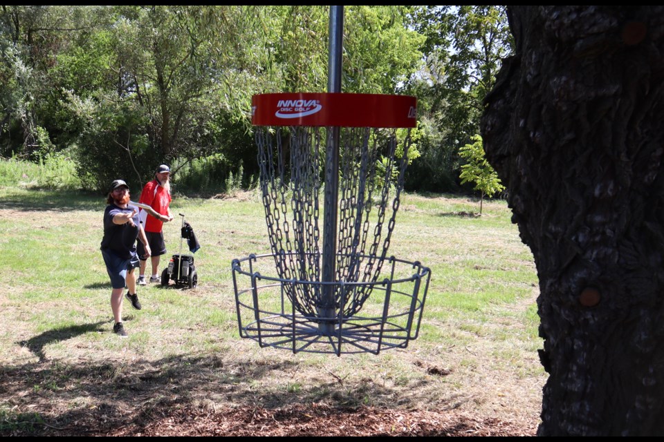 Harrison Bowler, of Cambridge, aims for the chains on the ninth hole of the Four Fathers Disc Golf course on opening day.