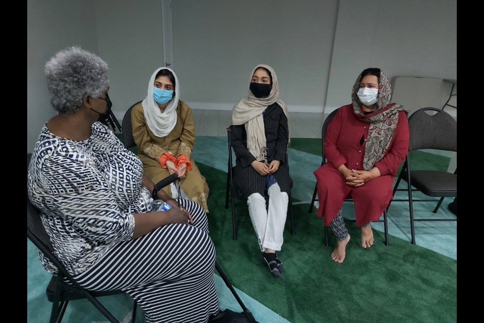 Marjorie Knight, left, talks to women from the Ahmadiyya Muslim community at the open house held Thursday at Baitul Kareem Mosque.