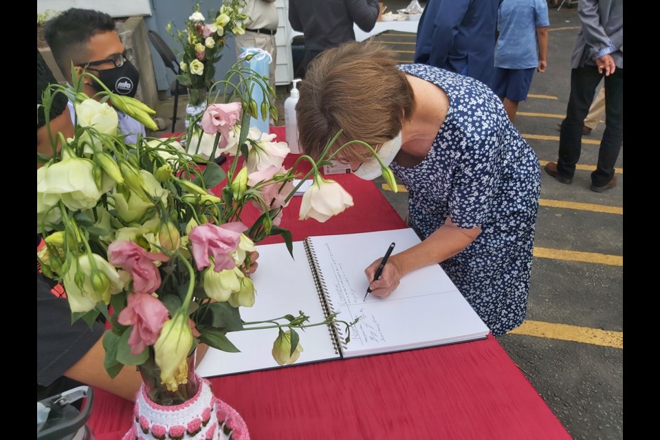 A Cambridge resident signs the guestbook at the Baitul Kareem Mosque open house held Thursday.