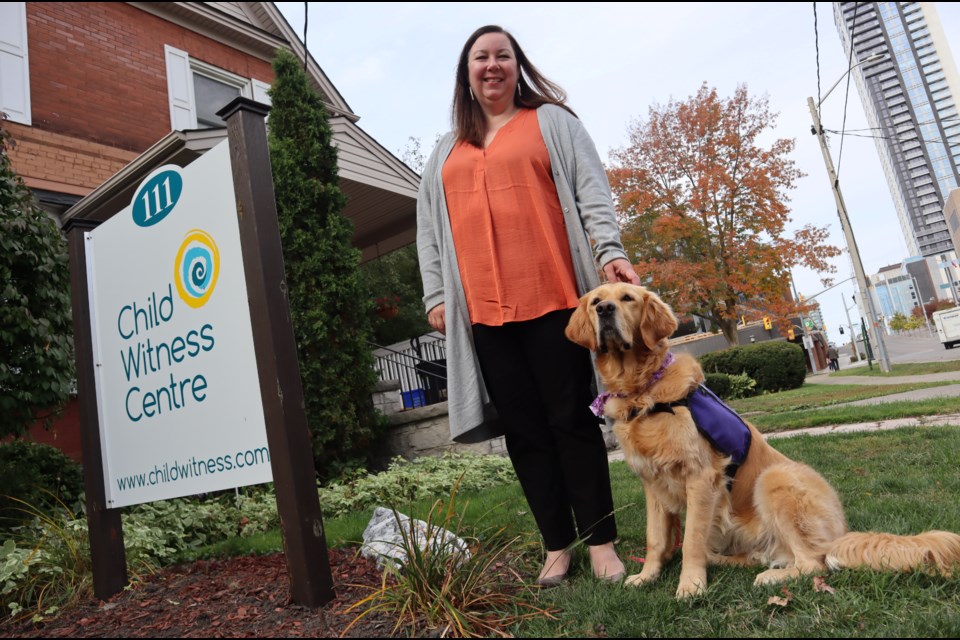 Kim Rodrigues, executive director at the Child Witness Centre, stands outside the Kitchener office with Monet, the first accredited facility dog in the criminal justice system in the Region of Waterloo.