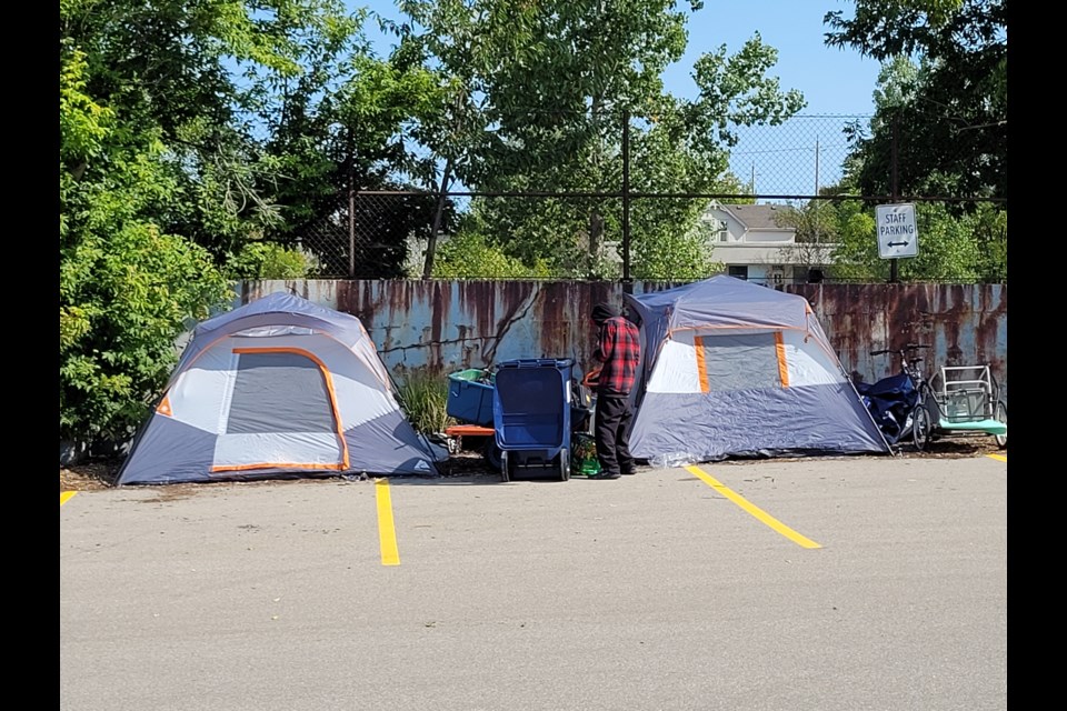Tents begin to line the perimeter of the back parking lot at 150 Main St. in Galt on Thursday after several unhoused individuals were told to move from the empty lot at 55 Kerr St.