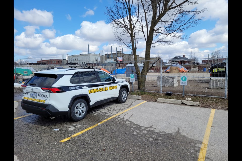 Security monitors the encampment at Victoria and Weber streets in Kitchener.