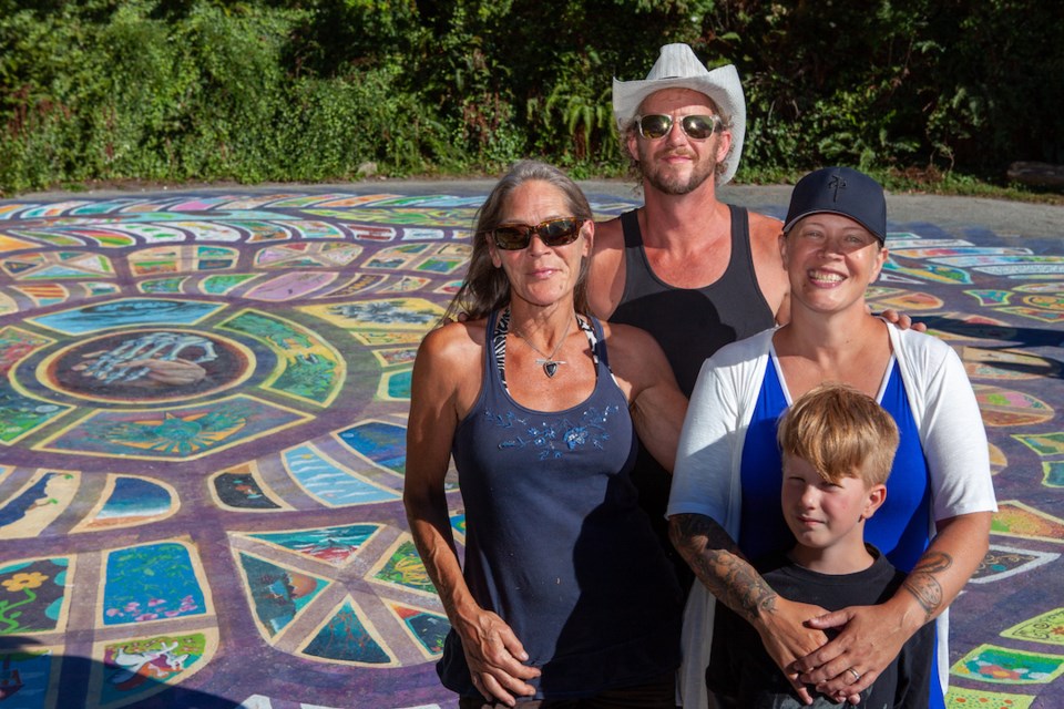 At the Roberts Creek mandala, artist Robert Marion surveys the finished artwork with his wife Johanna, their son (and fellow painter) Abraham, and coordinator Pamela Messner.