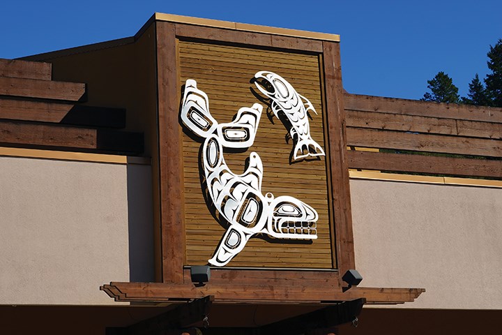 Five of the brushed aluminum metalworks, like this depiction of whale and salmon, have already been mounted at Tsain-Ko Centre.