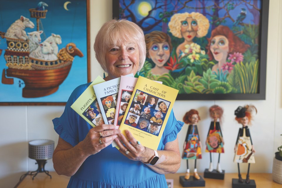 Artist Coralie Swaney is surrounded by her paintings, three-dimensional characters, and newly published books in her Gibsons studio.