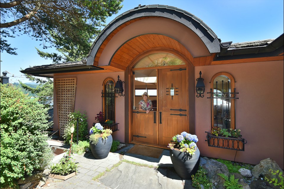 Franny Vandenberg leans from her polished wood dutch door to greet visitors to the spectacular home on the bluff in Gibsons.