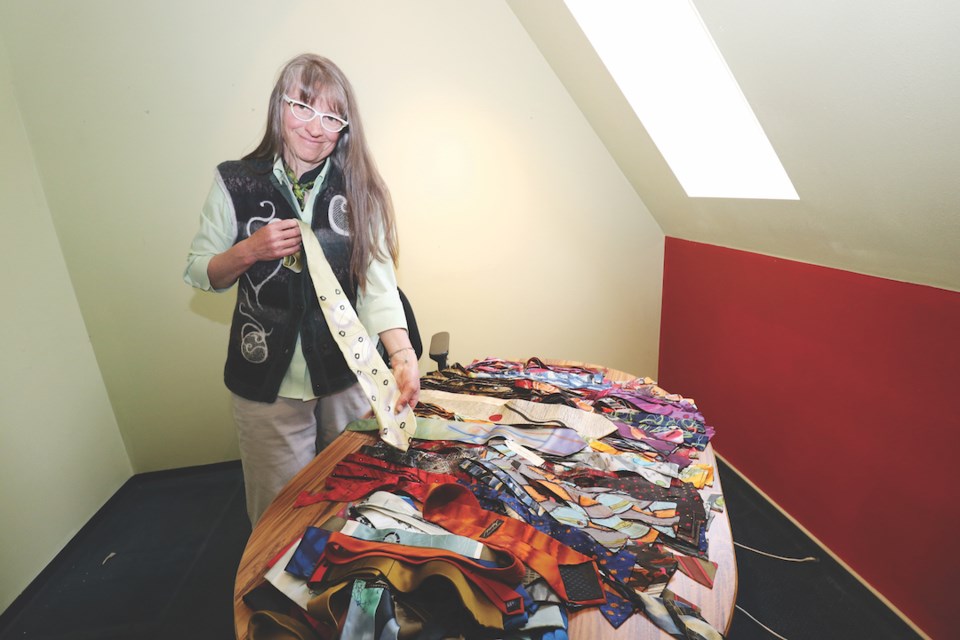 Artist Gabriele Beyer with more than 100 stolen ties recovered from a thrift shop on the Sunshine Coast.