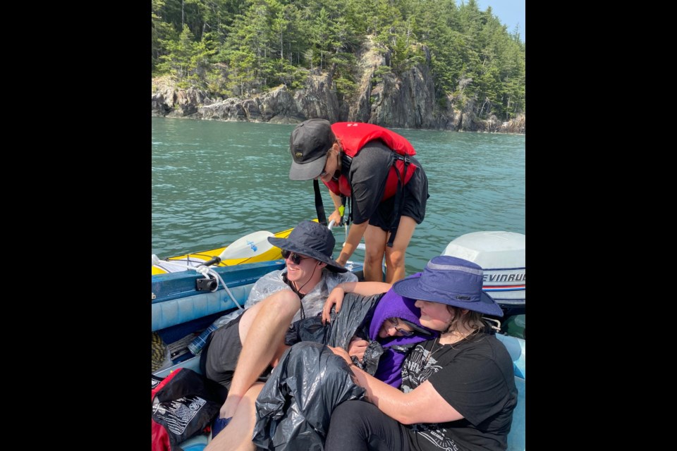 Crawford (wrapped in the towel) recovers in a support boat during her Aug. 19 Howe Sound swim.