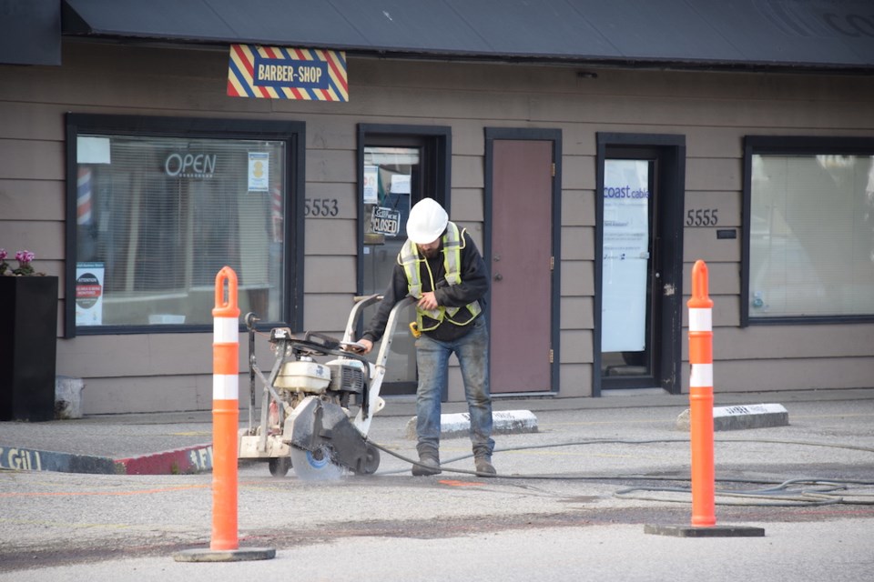 Worker cutting pavement