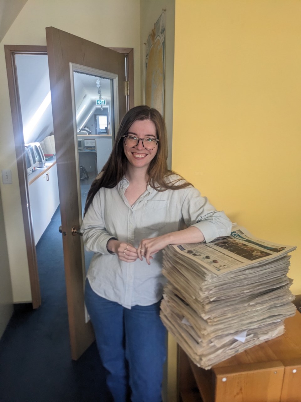 keili-bartlett-with-her-stack-of-newspapers