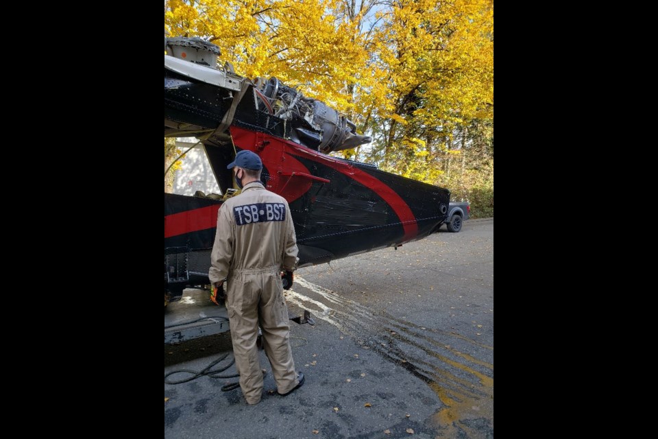 A Transportation Safety Board investigator and the helicopter wreckage at the TSB hangar in Richmond Hill.