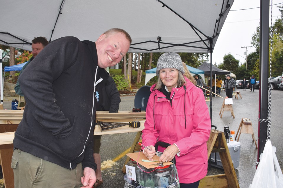 Steve flashes what he hopes is a good luck smile as he buys 50/50 tickets from sales volunteer Sue.