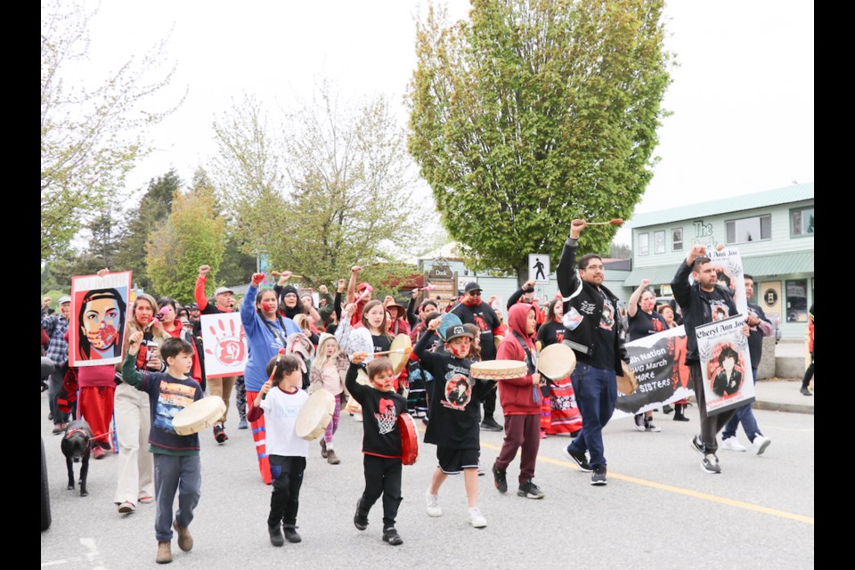 The crowd sang the Women's Warrior Song as they walked in shíshálh Nation’s first annual march for missing and murdered Indigenous women and girls, every four verses raising their fists. 