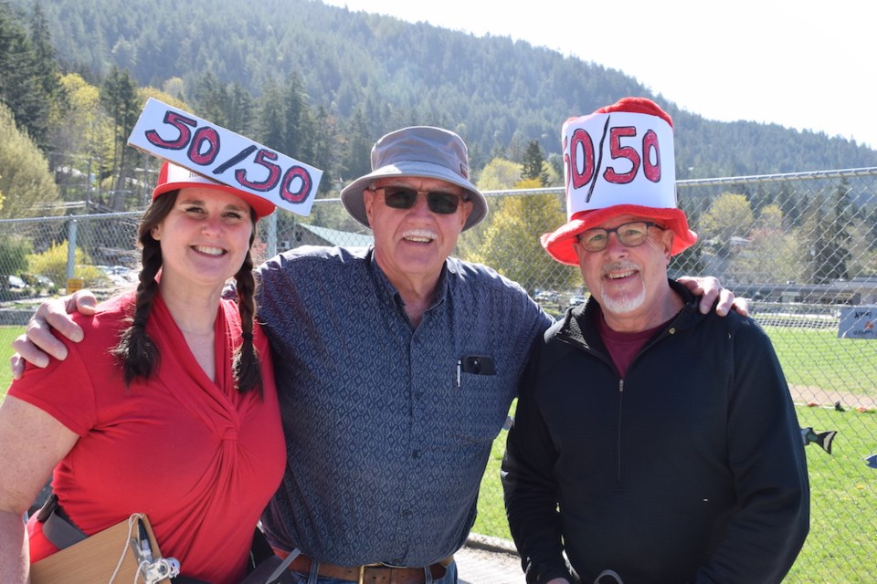 50/50 ticket venders Jennifer Wright, and Randy Picketts flank happy customer Jef Keighley