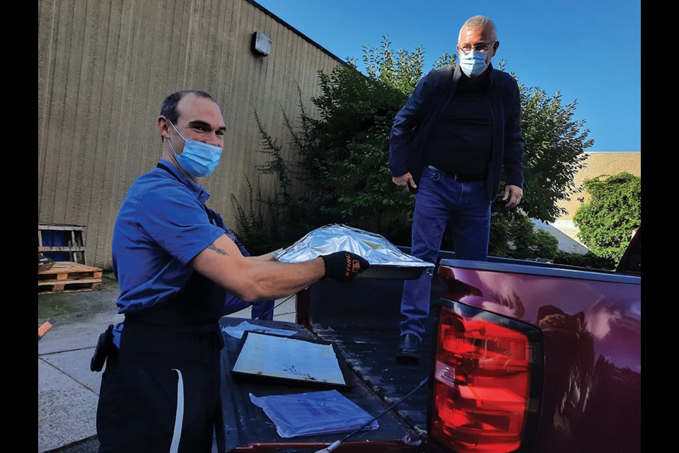 Manager Dave Diether helps Community Dinners organizer Kenan MacKenzie load one of the 27 turkeys generously donated (and roasted) by SuperValu Gibsons.