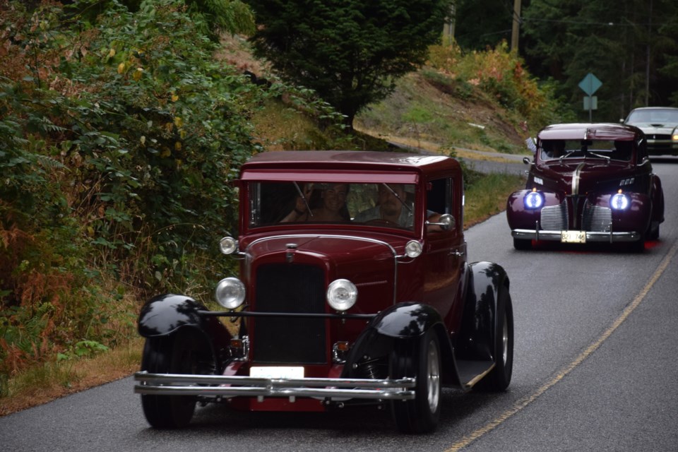 Classic cars roll along Halfmoon Bay’s Redrooffs Road in the Coasters Car Club’s “Covid Appreciation Cruise” on Aug 6.