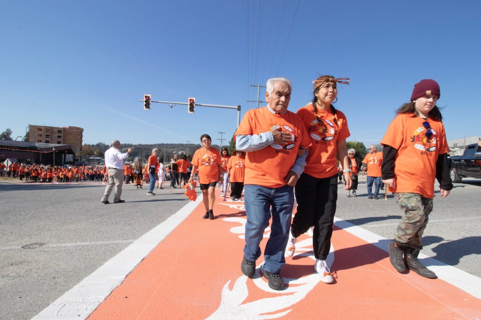 Thomas Paul Sr. and his great-granddaughter Lindsay August cut the ribbon to open the Reconciliation Crosswalk on Highway 101.